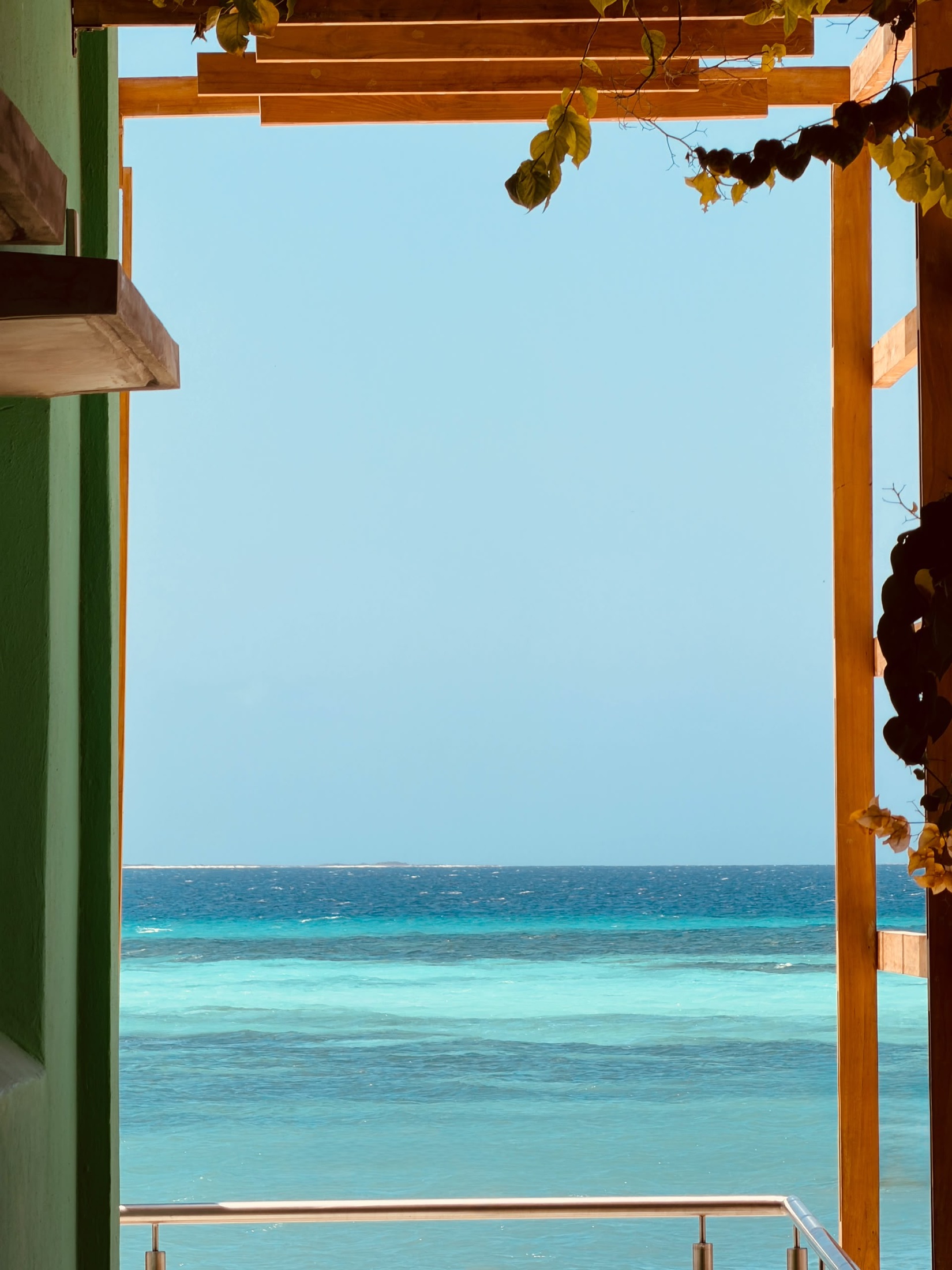 Vista al mar turquesa enmarcada por la pérgola